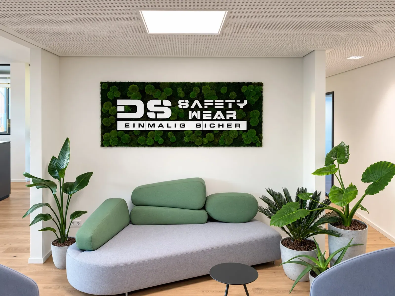 Empfangsbereich von DS SafetyWear in Köln mit Moosbild und Firmenlogo
